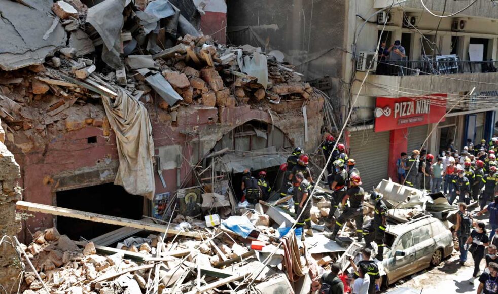 Stora delar av Beirut i spillror efter kraftig explosion. Här ses brandmän leta överlevare i rasmassorna. Bild: TT