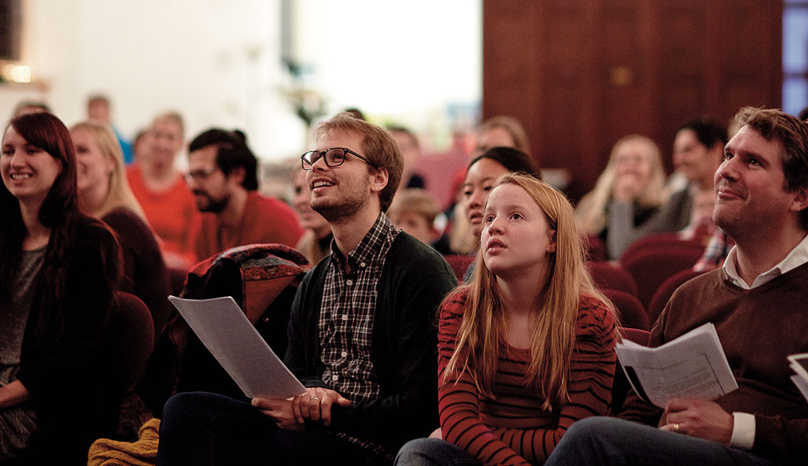Stämningen i adventsfirandet är god. Svenskarna tar ton i välkända och traditionsenliga julsånger.
