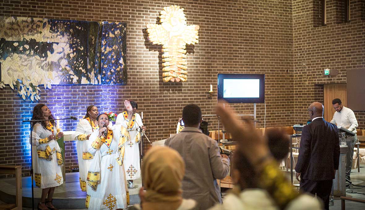 – Låt oss prisa Gud med hela hjärtat den här eftermiddagen, uppmanar lovsångsledaren innan ett 50-tal församlingsmedlemmar i Mekane Yesuskyrkan i Skärholmen reser sig i jubel. Bilder: Johan Ericson