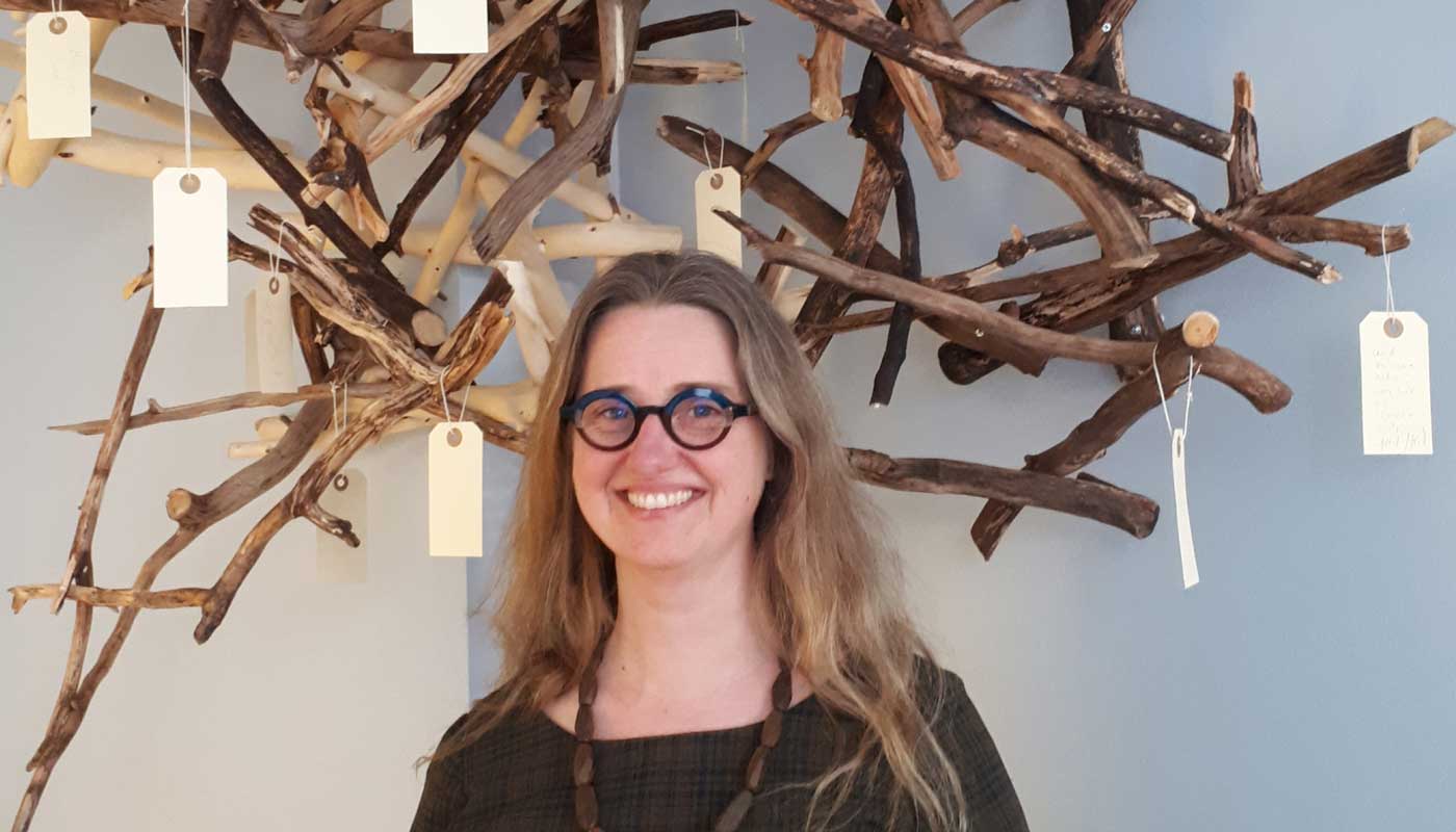 Konstnär Anna Lindkvist Adolfsson framför böneträdet i asp.