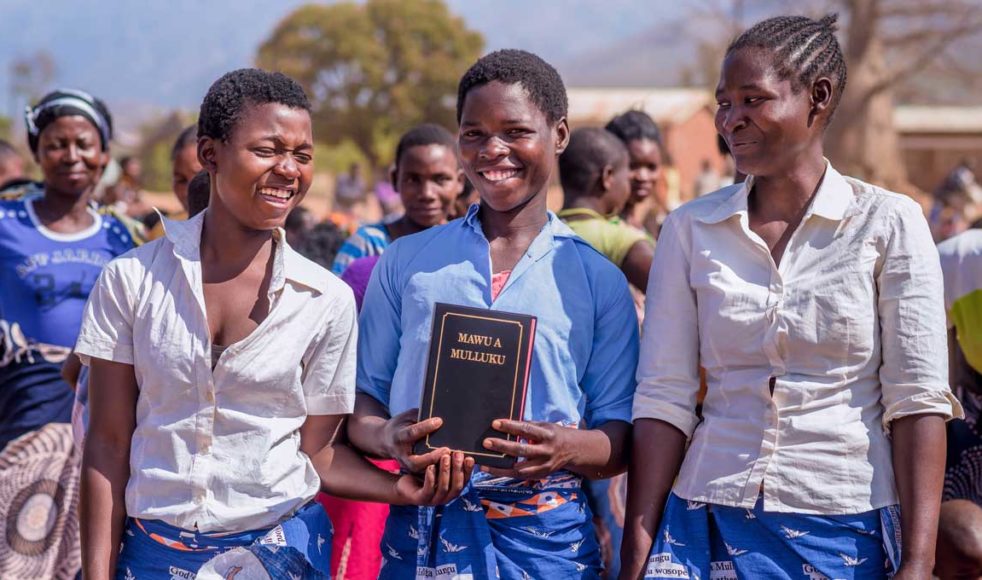 När Bibeln på ellomwe släpptes var glädjen stor. Dessa malawiska kvinnor bar kanga-tyg med bibelsällskapets logotyp och mönster dagen till ära.