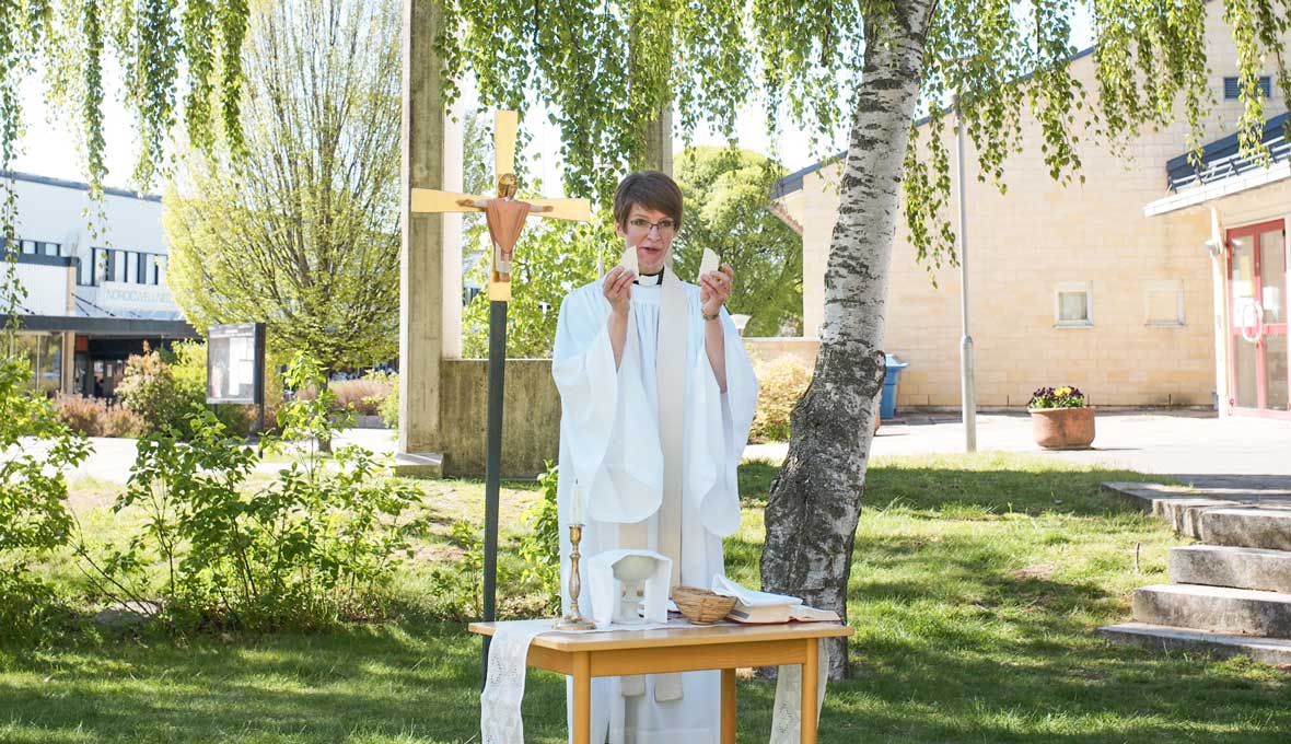 Församlingsherde Sara Nillson Edström leder en utomhusmässa intill Lötenkyrkan. Bild: Johan Ericson