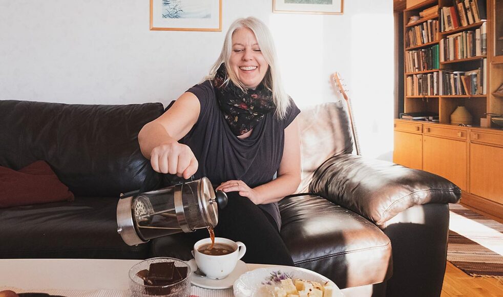 Maria bjuder på kaffe i en mugg med motivet av den samiska flaggan och berättar hur bra hon trivs i den lilla byn dit hon har flyttat. Bild: Lovisa Fundell