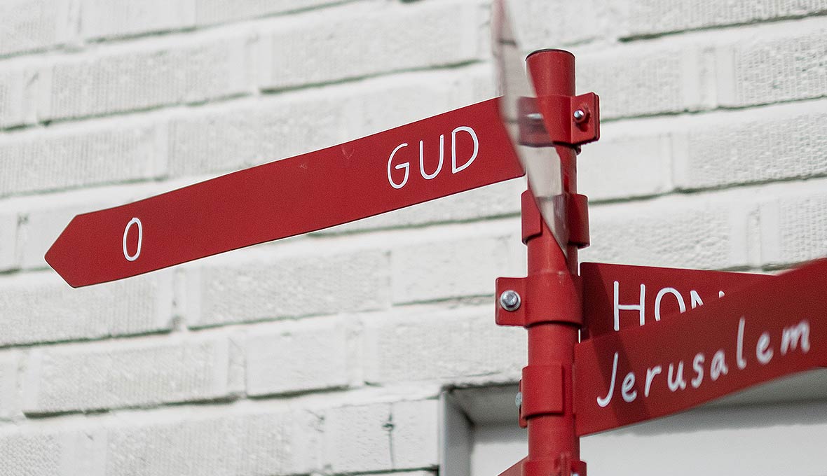 Stig-Åkes egentillverkade skylt står i trädgården och påminner om Guds närhet.