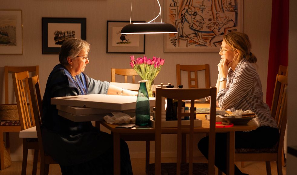 Vid sitt köksbord visar Erika Cyrillus Budbärarens Elin Sharew Svensson några av de 61 verken som utgör utställningen om Jona bok.